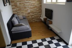 a living room with a couch and a television at Rab From Above Studio Apartment in Rab
