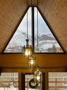 un lampadario a braccio in una stanza con una grande finestra di Luno Cottage a Kazbegi