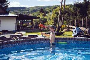 a young boy playing with a toy in a swimming pool at Chalúpka na konci in Banská Štiavnica