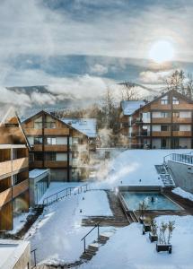 ein Resort im Schnee mit Pool in der Unterkunft Tremonti Hotel Karpacz in Karpacz