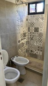 a bathroom with a toilet and a sink at La Maga in Santa Rosa de Calamuchita