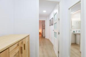 a white kitchen with a counter and a hallway at Delfin -Punta Umbria- in Punta Umbría +23 photos