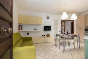 a kitchen and living room with a green couch and a table at Piccolo Angolo Di Tranquillità in Poggibonsi +13 photos