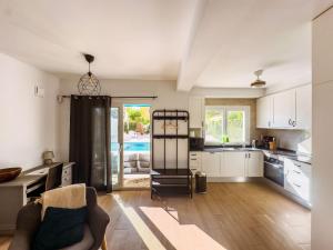 a kitchen with white cabinets and a living room at Beach Villa Playa Flamenca in Orihuela Costa