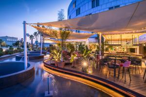 a hotel patio with a pool and tables and chairs at Barceló Sevilla Renacimiento in Seville