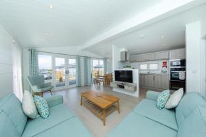a living room with a blue couch and a table at Gull Rocks Beach Lodges in Cubert