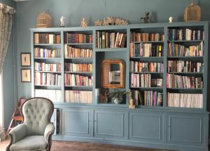 a large blue book shelf filled with books at Château des Fouilloux in Agris
