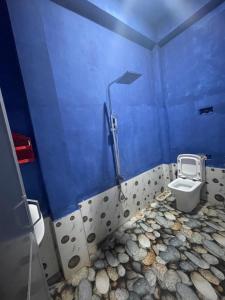 a bathroom with a toilet in a blue wall at Saa in Anuradhapura