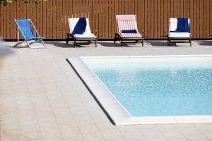3 sillas y una piscina en un patio en Casa Natia - IsulaTravel, en Módica