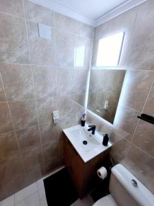 a bathroom with a sink and a toilet and a mirror at Solymar Torrevieja in Torrevieja +10 photos