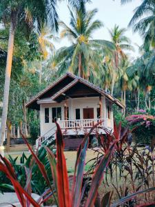 Una pequeña casa blanca con palmeras y plantas. en MY HOME Resort - Koh phangan vacation house rentals, en Ban Madua Wan