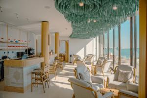un salone con sedie e un bar con vista sull'oceano di Hawar Resort By Mantis a Hawar Island