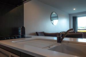 a kitchen with a sink and a mirror on a counter at Chic Urban Retreat in Grey Lynn in Auckland