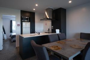 a kitchen with a table and some chairs and a counter at Chic Urban Retreat in Grey Lynn in Auckland