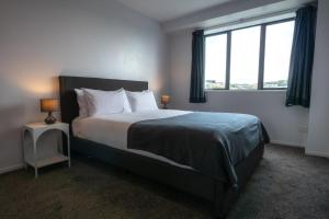 a bedroom with a large bed with a large window at Chic Urban Retreat in Grey Lynn in Auckland