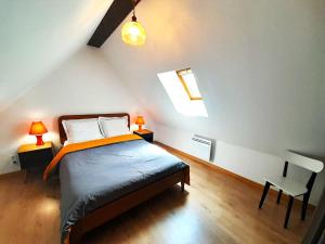 a bedroom with a bed and two lamps and a chair at Gite Porte de Champagne Levroux in Levroux