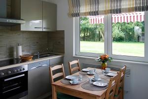 a kitchen with a wooden table with chairs and a window at Adams Schwedenhaus in Dechow