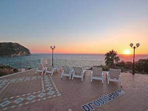 um grupo de cadeiras e o oceano ao pôr do sol em Hotel Terme Providence em Ischia