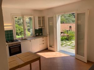a kitchen with an open door to a garden at Appartamento Pitosforo e Camera Melograno in Leivi +12 photos