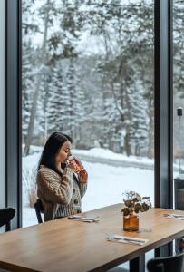 eine Frau sitzt an einem Tisch und isst eine Pizza in der Unterkunft Tremonti Hotel Karpacz in Karpacz + 64 Fotos