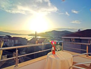 - une table avec un verre de vin sur le balcon dans l'établissement Apartments Kairos, à Seget Vranjica