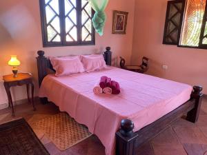 ein Schlafzimmer mit einem rosa Bett mit einer rosa Blume darauf in der Unterkunft Casa Paraiso in Paulista