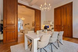 une salle à manger avec une table et des chaises blanches dans l'établissement B&B Leopold Appartementen & studio's, à Saint-Trond