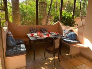ein kleiner Tisch und Stühle auf einem Balkon mit einem Tisch und einem Fenster in der Unterkunft Casa Paraiso in Paulista