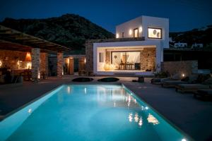 a villa with a swimming pool at night at Villa Anamnisis in Naxos Chora