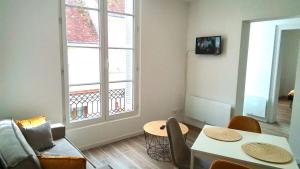 a living room with a couch and a table and a window at Valençay appart chic 2 chambres in Valençay