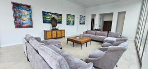 a living room with couches and a table and paintings at Villa Princess Stephanie in Kata Beach