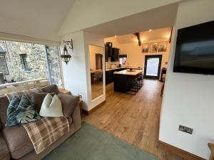 a living room with a couch and a kitchen at Cuddfan in Holyhead