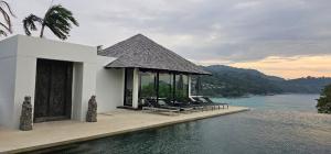 a group of chairs sitting next to a swimming pool at Villa Princess Stephanie in Kata Beach
