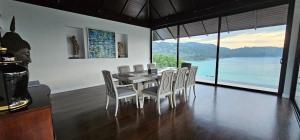 a dining room with a table and chairs with a view at Villa Princess Stephanie in Kata Beach