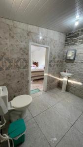 a bathroom with a toilet and a sink and a bed at Bom gosto tutoia in Tutóia
