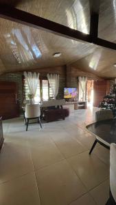 a large living room with tables and a tv at Bom gosto tutoia in Tutóia
