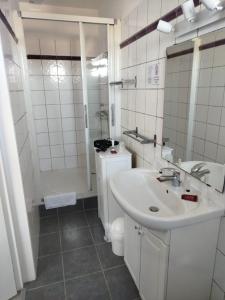 a white bathroom with a sink and a toilet at Hotel Le Crist Al, Front de mer, chambres climatisées et son studio non climatisé, proche du centre ville in Saint-Georges-de-Didonne +76 photos