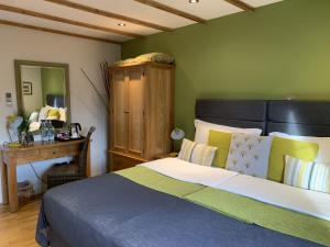 a bedroom with a bed and a desk and a mirror at Bath House Hotel & Restaurant in Chard