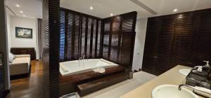 a bathroom with a tub and a sink and a bed at Villa Princess Stephanie in Kata Beach