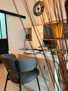 a chair sitting in front of a desk with a clock at Chtx-Style ancien - Fibre - Commerces - Transports in Châteauroux