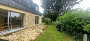 a backyard with a stone walkway next to a house at Maison de Vacances en bord de mer in Saint-Gildas-de-Rhuys