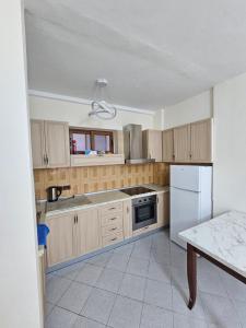 ドゥラスにあるEnles Downtown Apartmentの木製のキャビネットと白い冷蔵庫を備えたキッチン