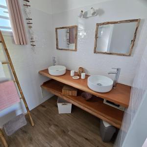 une salle de bain avec deux lavabos et un miroir dans l'établissement Ti'Tranquille, à Saint-François