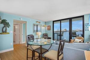 Una sala de estar con una mesa de cristal y sillas. en Lovers Key Beach Club #303 by Sun Palace Vacations, en Fort Myers Beach