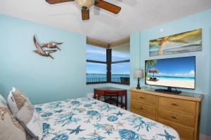 Un dormitorio con una cama y un televisor de pantalla plana. en Lovers Key Beach Club #303 by Sun Palace Vacations, en Fort Myers Beach