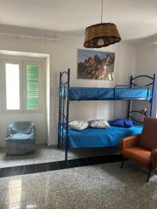 a bedroom with two bunk beds and a chair at Daria in Santa Teresa Gallura