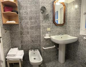 a bathroom with a sink and a toilet and a mirror at Daria in Santa Teresa Gallura +18 photos
