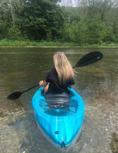 a woman in a blue kayak in the water at WaterFront Cabin Hot Tub Kayaks Firepit Game Consoles in Tunkhannock