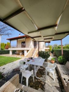 a patio with a table and chairs under an umbrella at LoGGOS VILLA in Lóngos