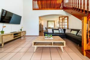 a living room with a couch and a coffee table at Villa Horizon Bleu - Vue Mer & Piscine Chauffée in Le Tampon